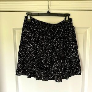 Ruffled mini skirt. Side zipper. Front/side ruching detail and tie